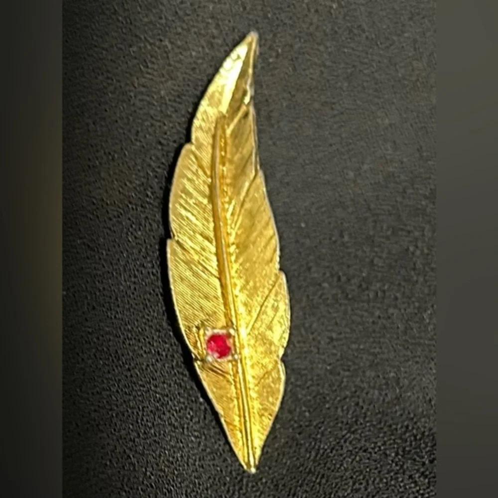 Gold finish Feather Brooch with Red Gemstone